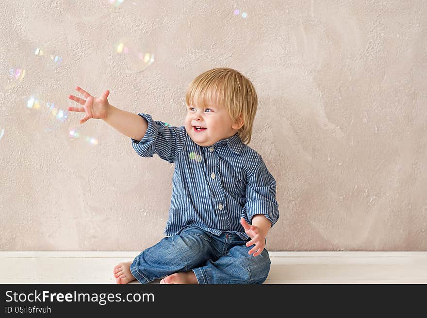 Laughing kid playing with soap bubbles. Laughing kid playing with soap bubbles