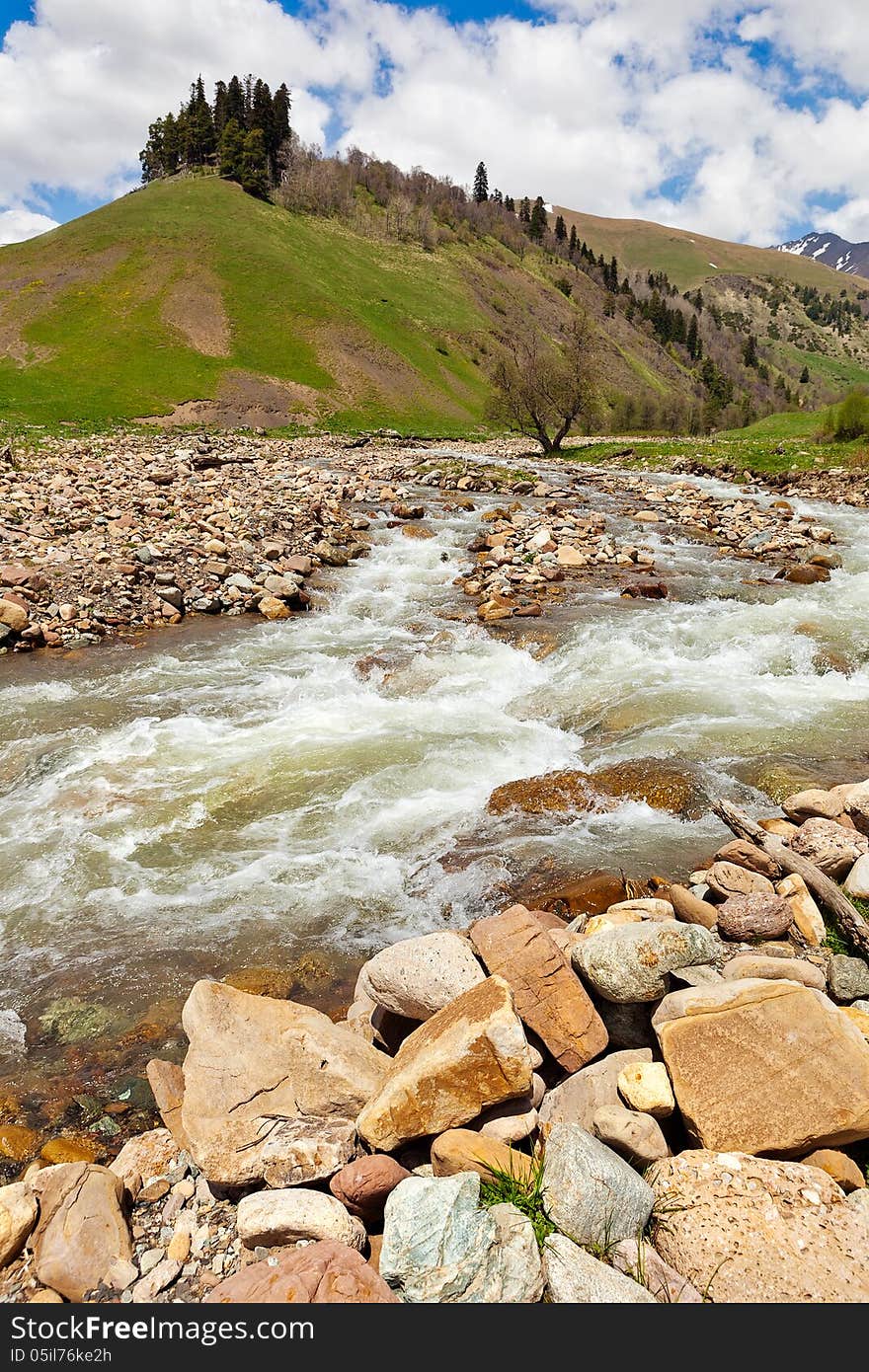 View to the foothills of the Caucasus mountains over stream near Arkhyz, Karachay-Cherkessia, Russia. View to the foothills of the Caucasus mountains over stream near Arkhyz, Karachay-Cherkessia, Russia