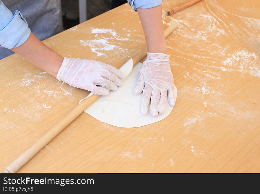 Woman's hands kneading dough with rolling pin for pie. Woman's hands kneading dough with rolling pin for pie