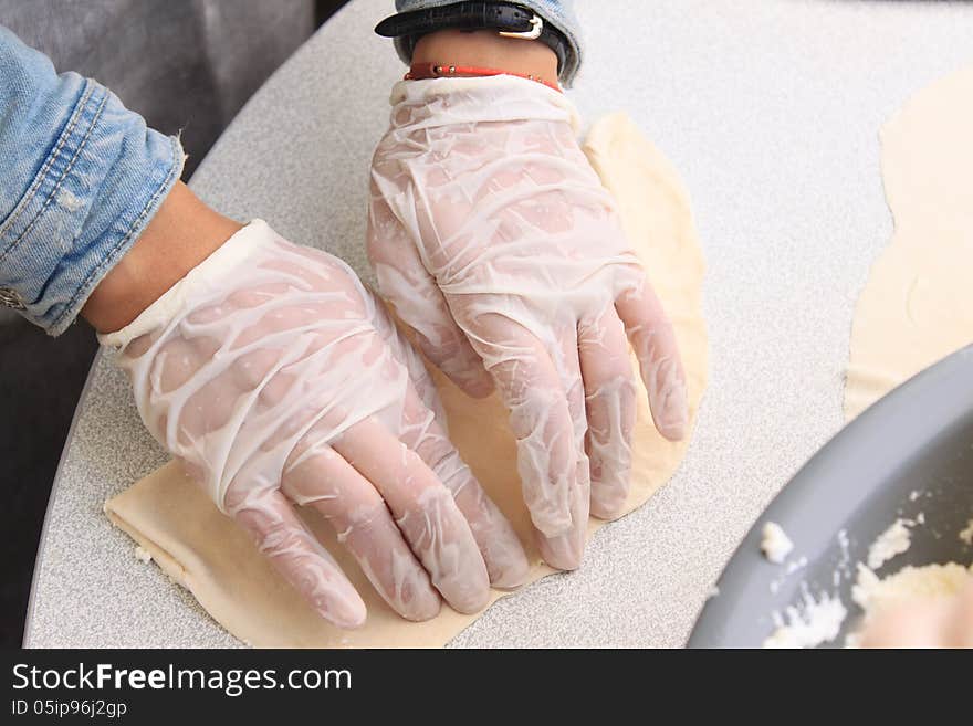 Pie crust made from flour and water to clean hands covered with plastic gloves