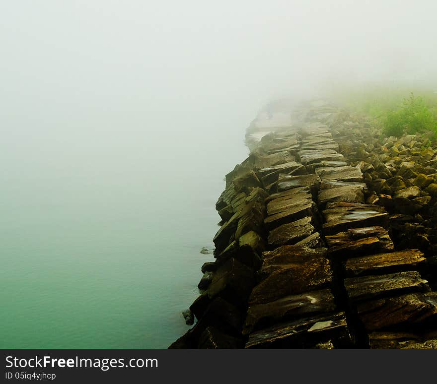 Misty Lake with a stone wall. Misty Lake with a stone wall.