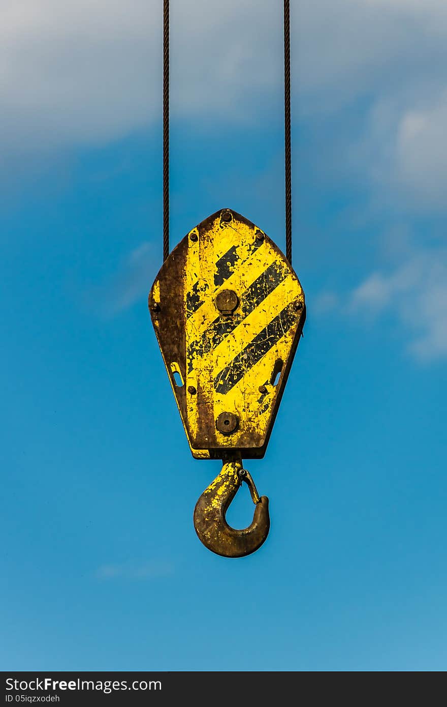 Yellow crane hook at the blue sky