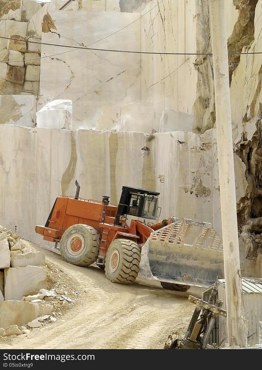 Excavators working for the transport of white marble, cut into blocks. Excavators working for the transport of white marble, cut into blocks