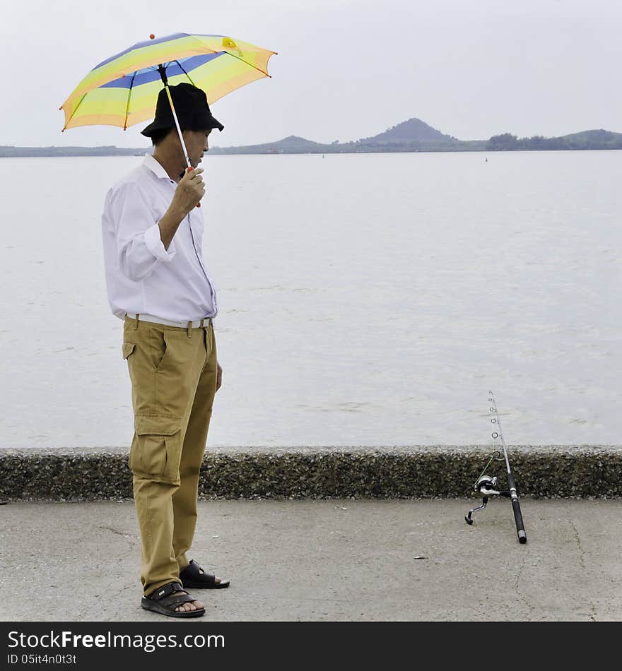 Senior fisherman waiting for catches a fish