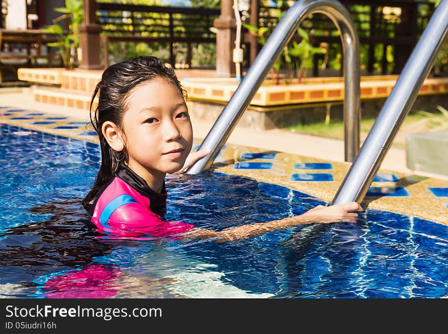 Girl relaxing on the side of a swimming pool. Girl relaxing on the side of a swimming pool