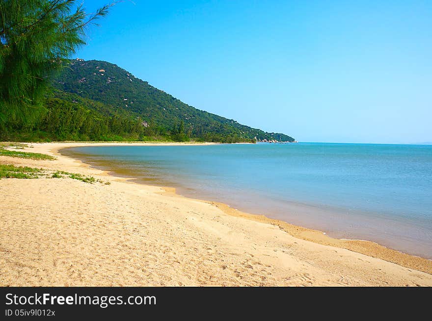 Wild beach on the tropical island against mountains and the blue sky. Wild beach on the tropical island against mountains and the blue sky.