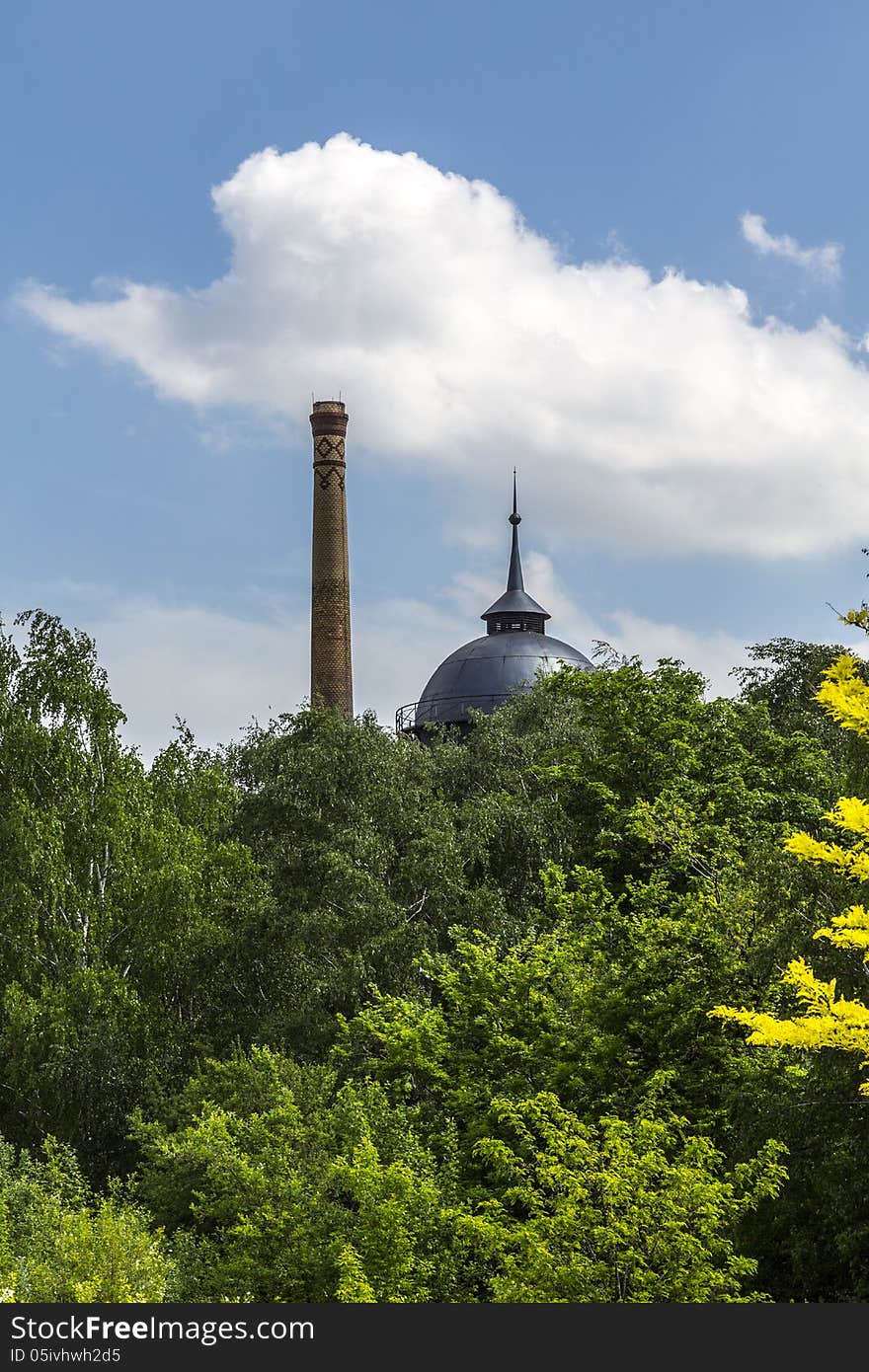 Vintage chimney and water tank behinde a forest