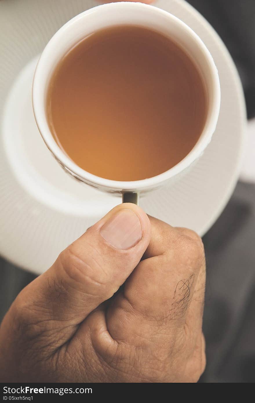 A hand ilfts a cup of tea