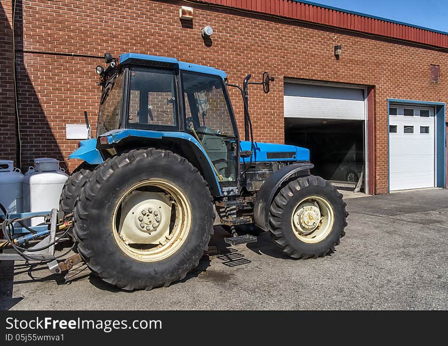 Blue tractor parked under a clean blue sky