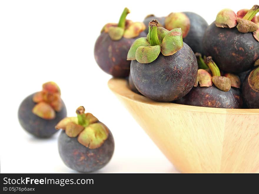 Mangosteen in a wooden bowl on white