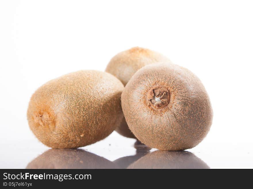 Kiwi fruit on a white background, reflected in the table. whole fruit. Kiwi fruit on a white background, reflected in the table. whole fruit.