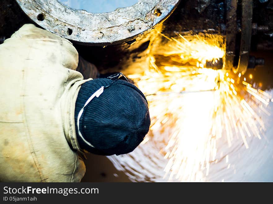 Oxygen-cutting operator cuts bolts in a cell with water.Water and fire.