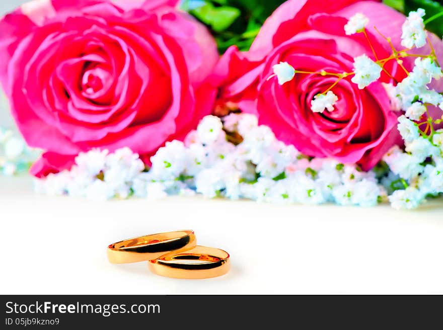 Wedding rings with rose on a white background