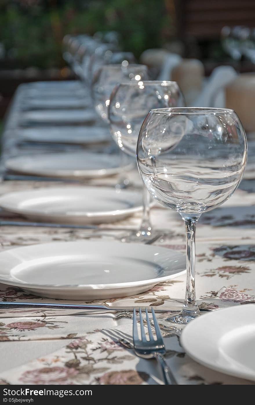 Empty footed tumblers,glasses and party plates on festive served table. Empty footed tumblers,glasses and party plates on festive served table