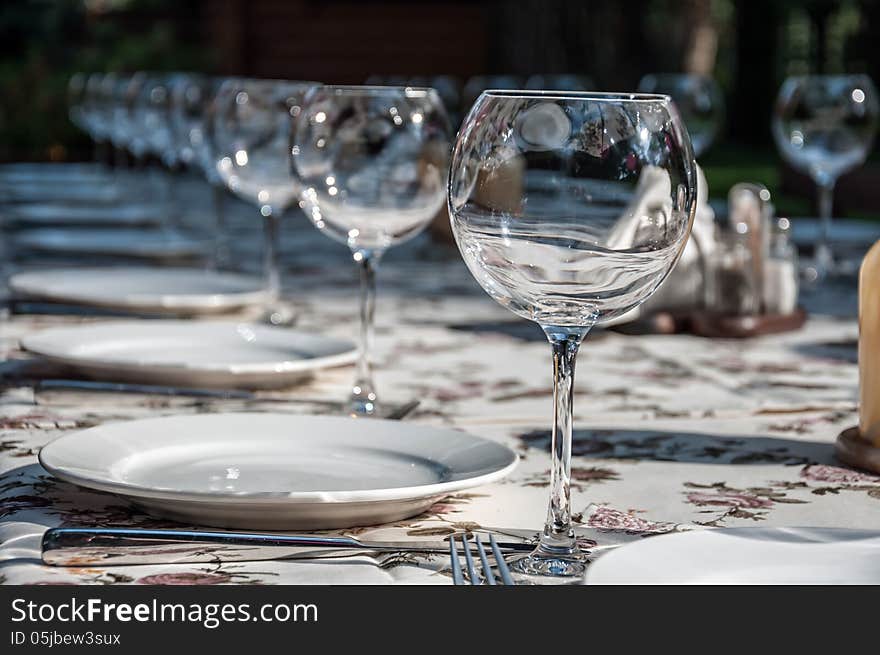 Empty footed tumblers,glasses and party plates on festive served table. Empty footed tumblers,glasses and party plates on festive served table