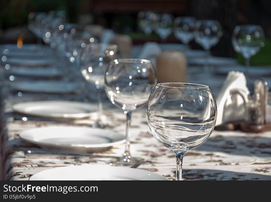 Empty footed tumblers,glasses and party plates on festive served table. Empty footed tumblers,glasses and party plates on festive served table