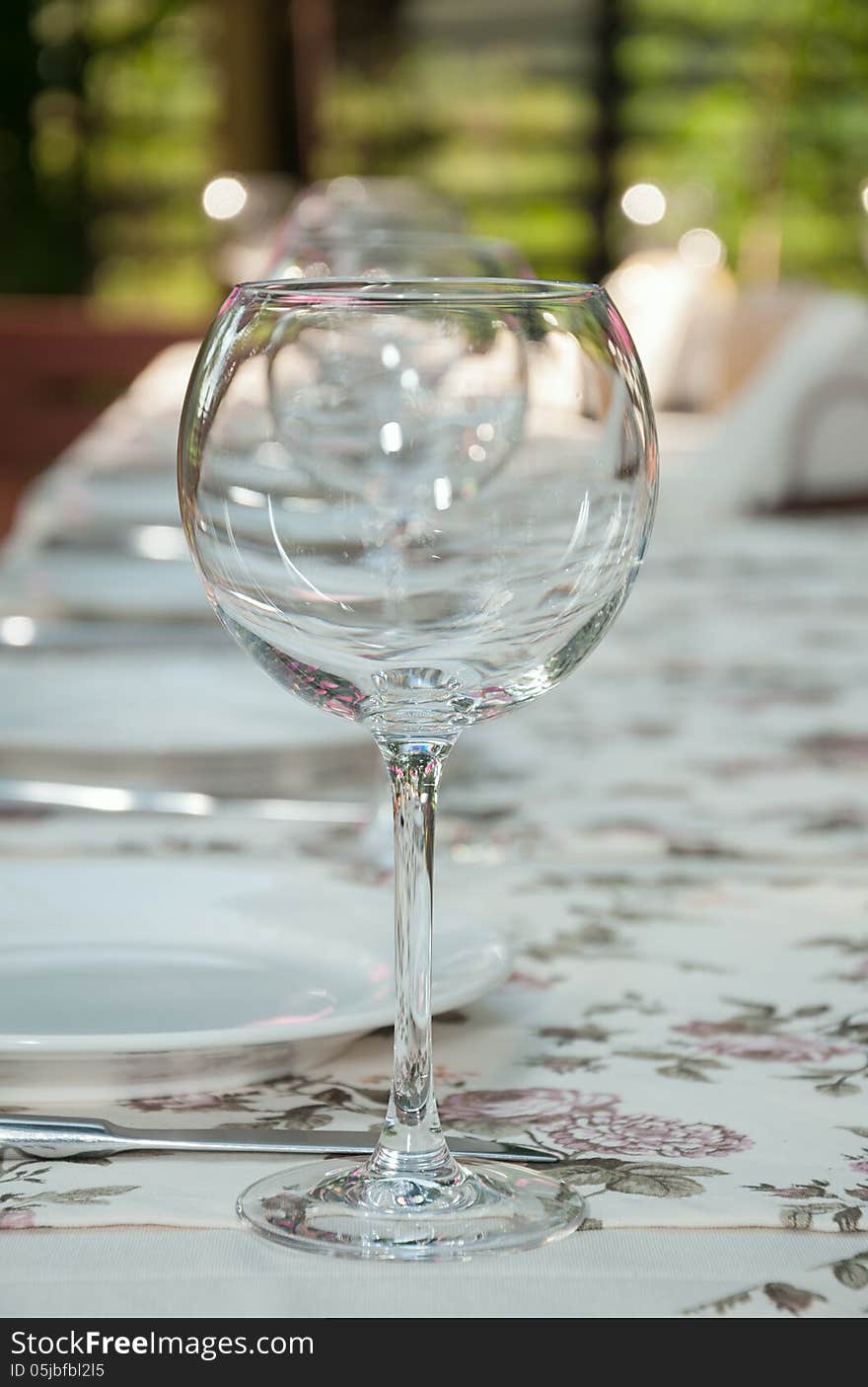 Empty footed tumblers,glasses and party plates on festive served table. Empty footed tumblers,glasses and party plates on festive served table