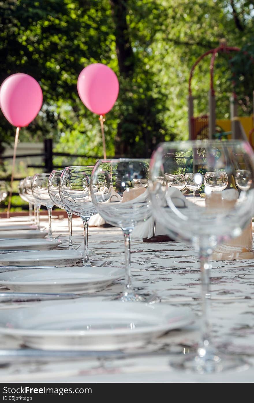 Empty footed tumblers,glasses and party plates on festive served table. Empty footed tumblers,glasses and party plates on festive served table