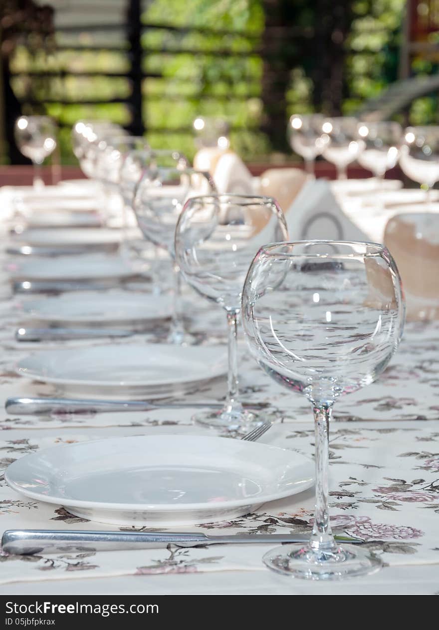 Empty footed tumblers,glasses and party plates on festive served table. Empty footed tumblers,glasses and party plates on festive served table