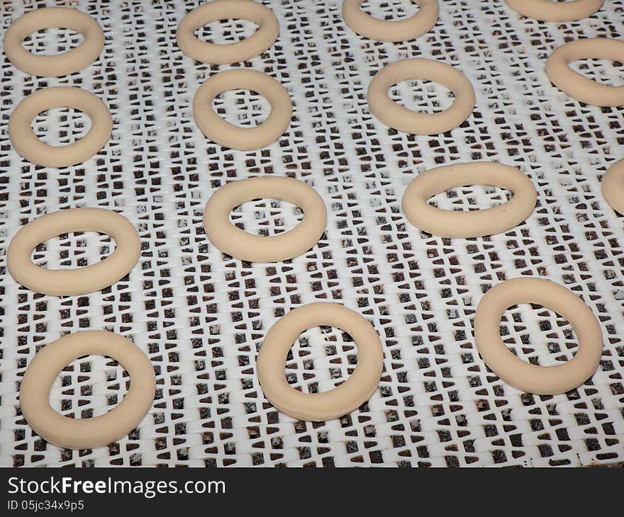 Crude forms of bagels on a conveyor.