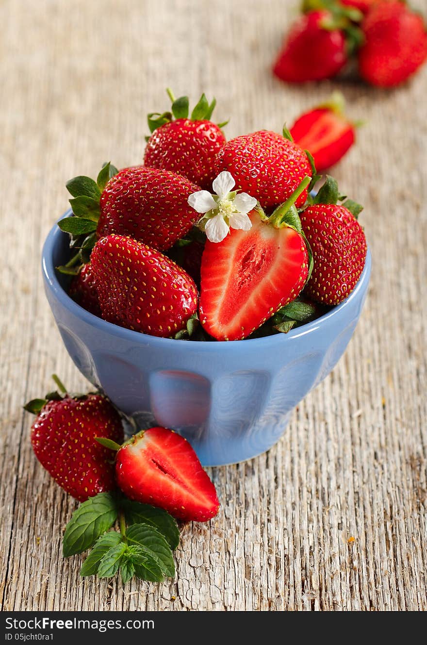 Blue bowl with fresh strawberries on wood. Blue bowl with fresh strawberries on wood