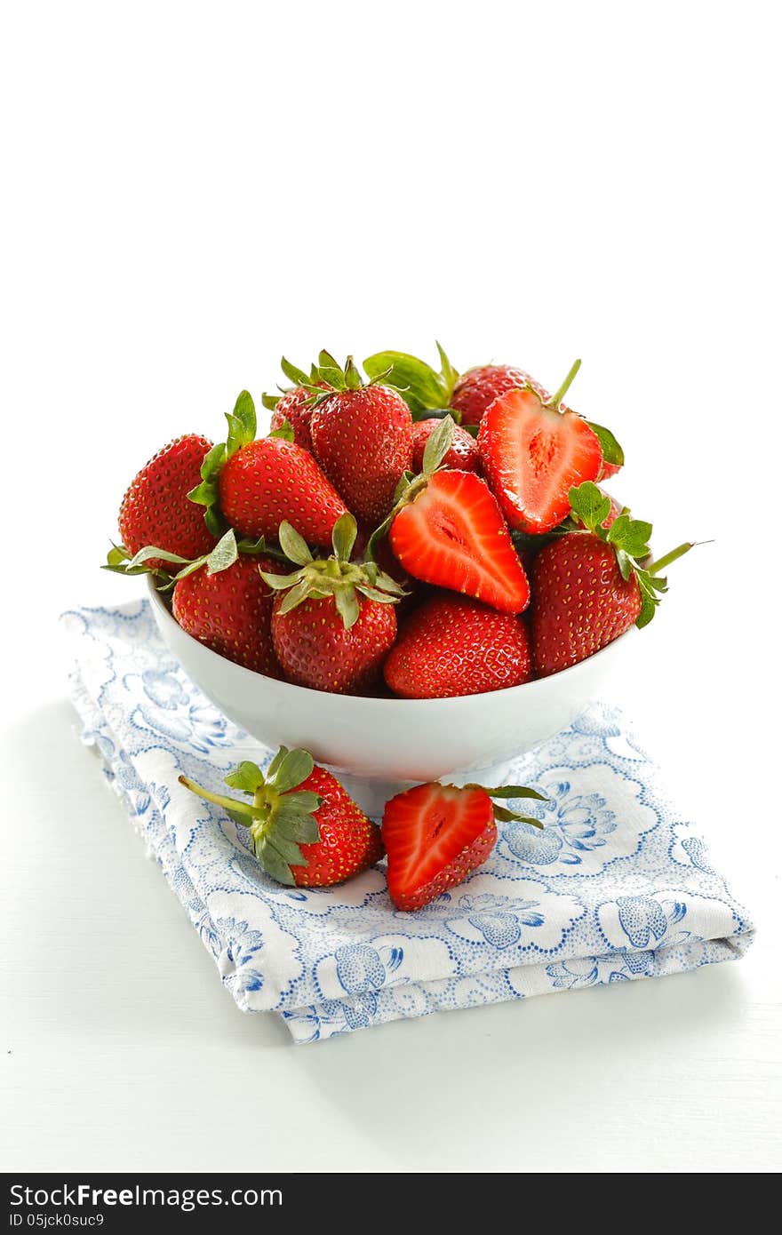 White bowl with fresh strawberries on blue napkin. White bowl with fresh strawberries on blue napkin