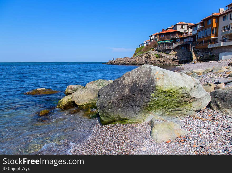 Seascape old town with rocks in the foreground