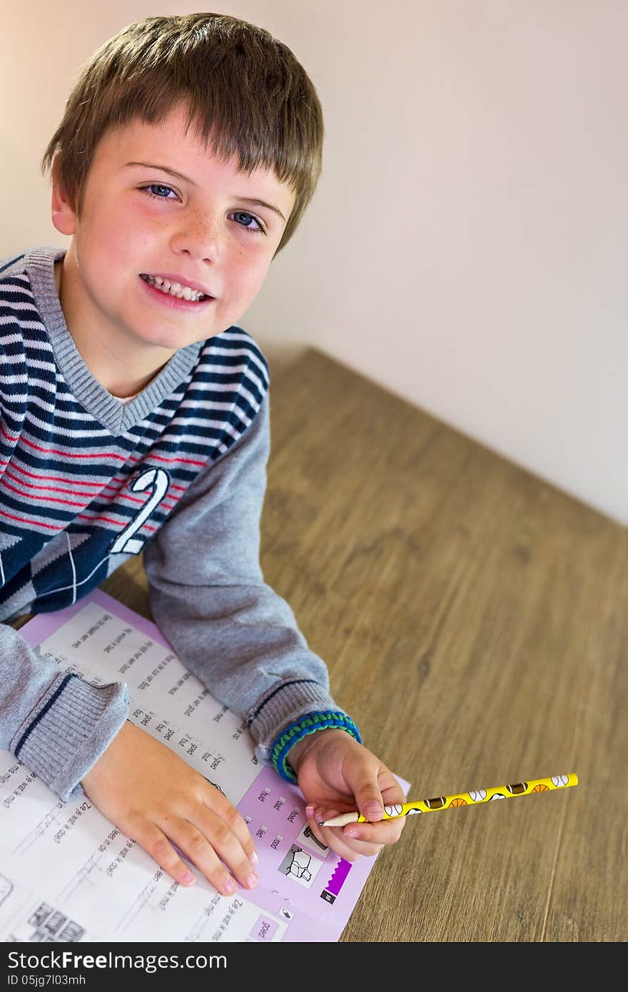 Kid making his homework, with a smile