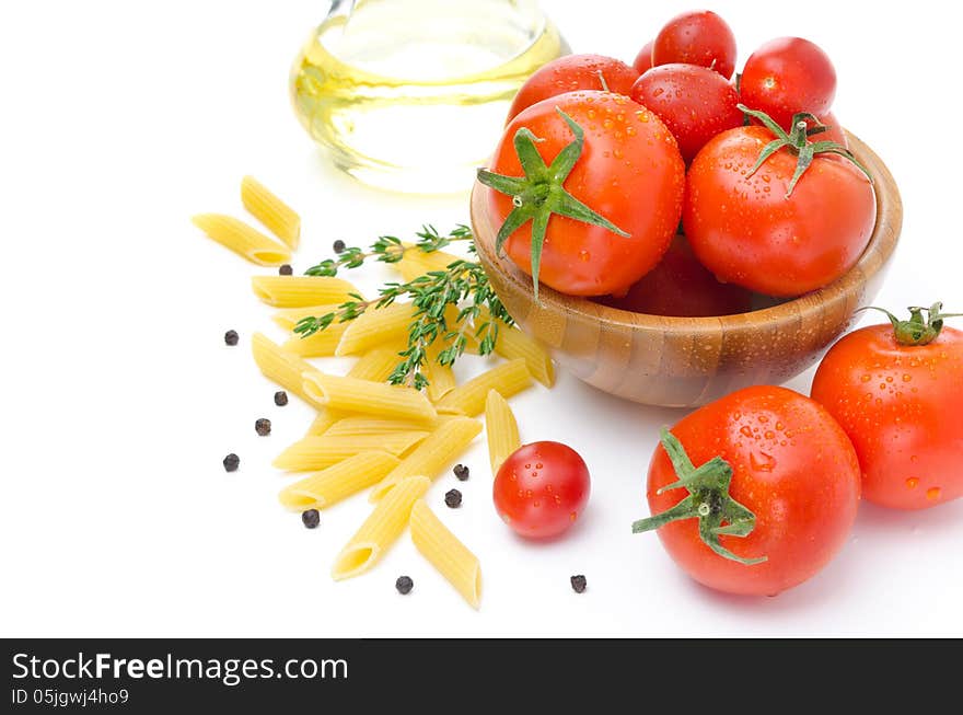 Fresh tomatoes, pasta penne, olive oil and spices on a white