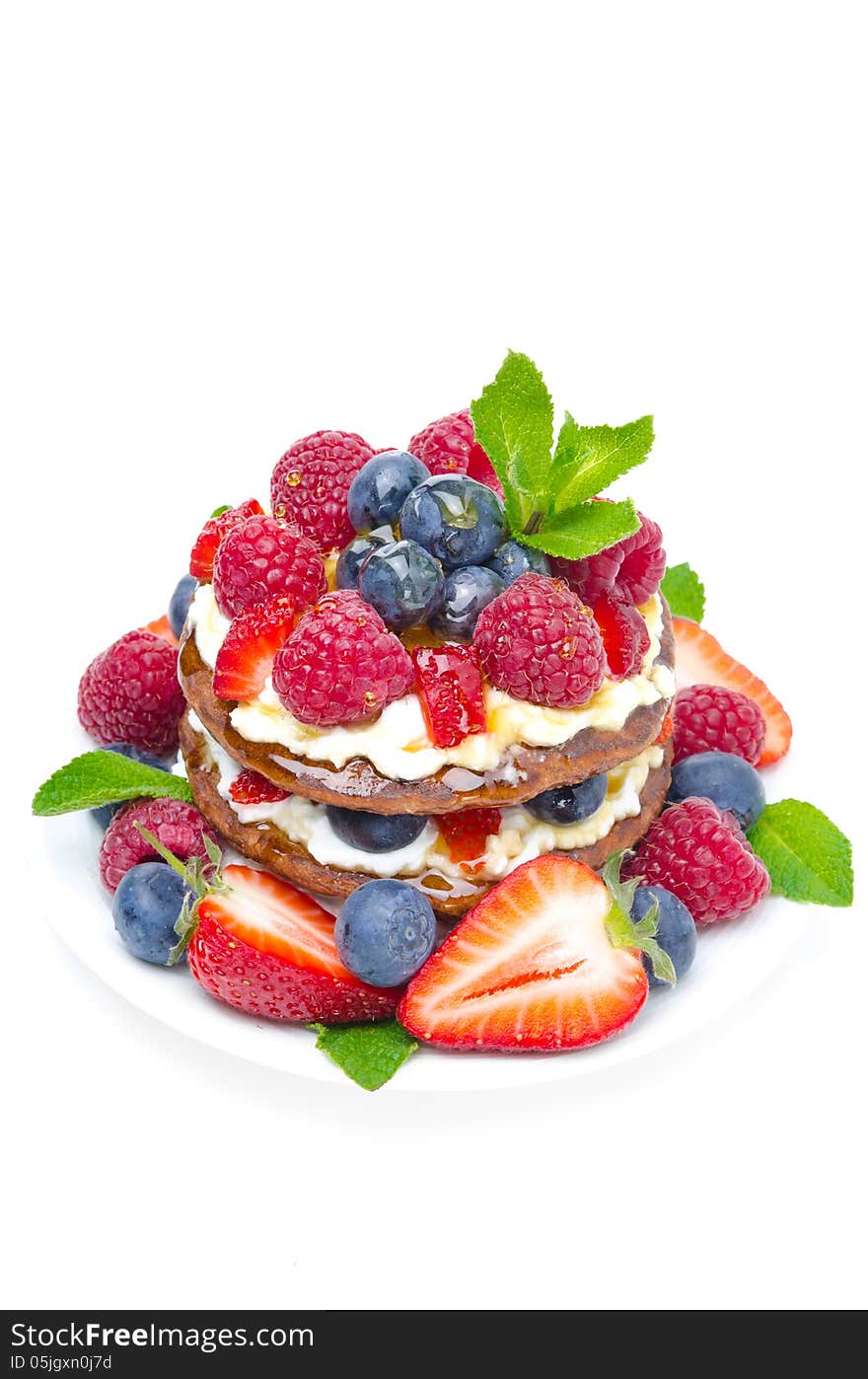 Pancakes with whipped cream and fresh berries isolated