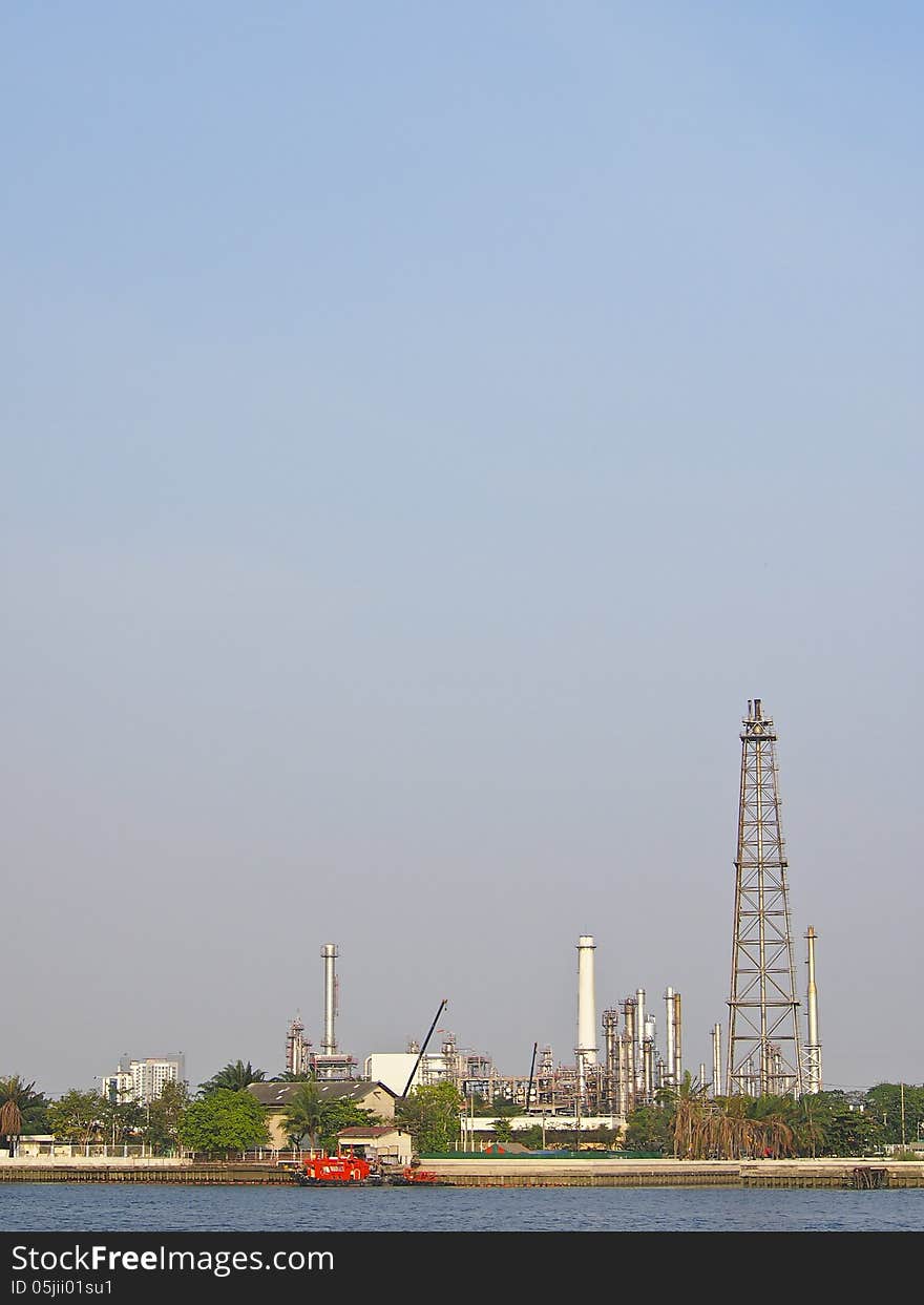 Tower of oil refinery along side of river