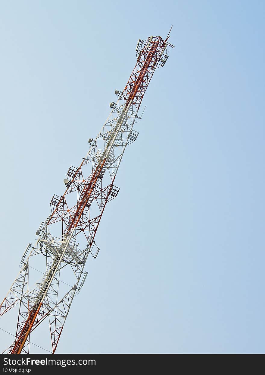 White and red high telecommunication antenna in daytime