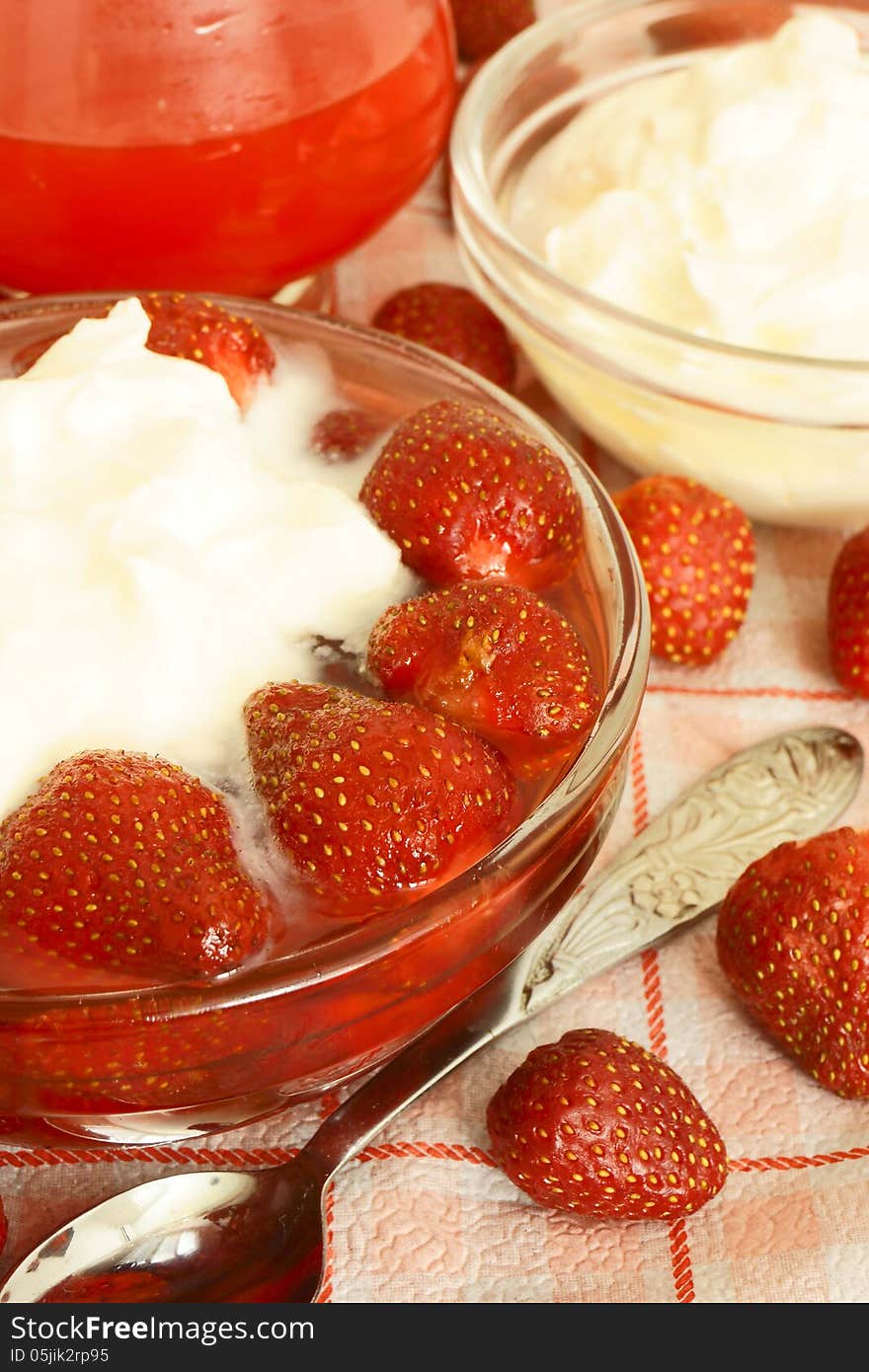 Strawberries in syrup with cream, sweet dessert.