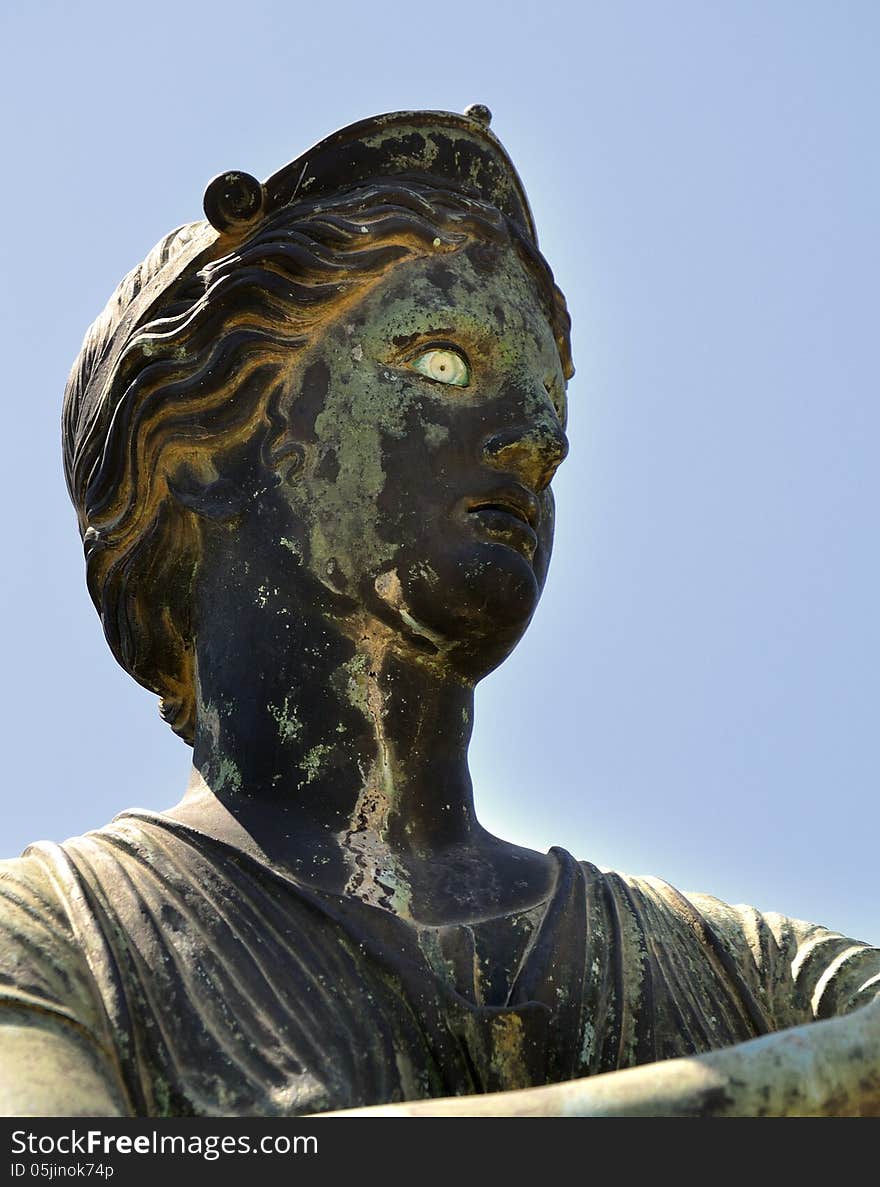 Ancient Roman bronze statue of Diana against blue sky in the Temple of Apollo, Pompeii, Italy. Ancient Roman bronze statue of Diana against blue sky in the Temple of Apollo, Pompeii, Italy