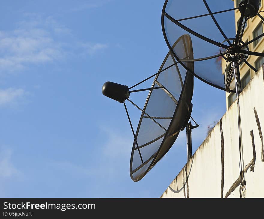 Group of black satellite dish on building in sunlight