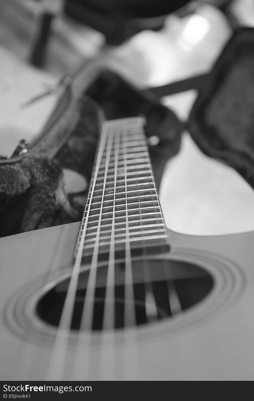 An acoustic guitar seen by the side, with strings out of focus