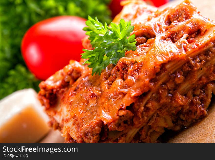 Closeup lasagna on a wooden board. Closeup lasagna on a wooden board