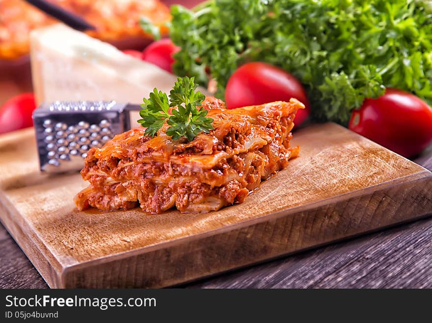 Closeup lasagna on a wooden board. Closeup lasagna on a wooden board