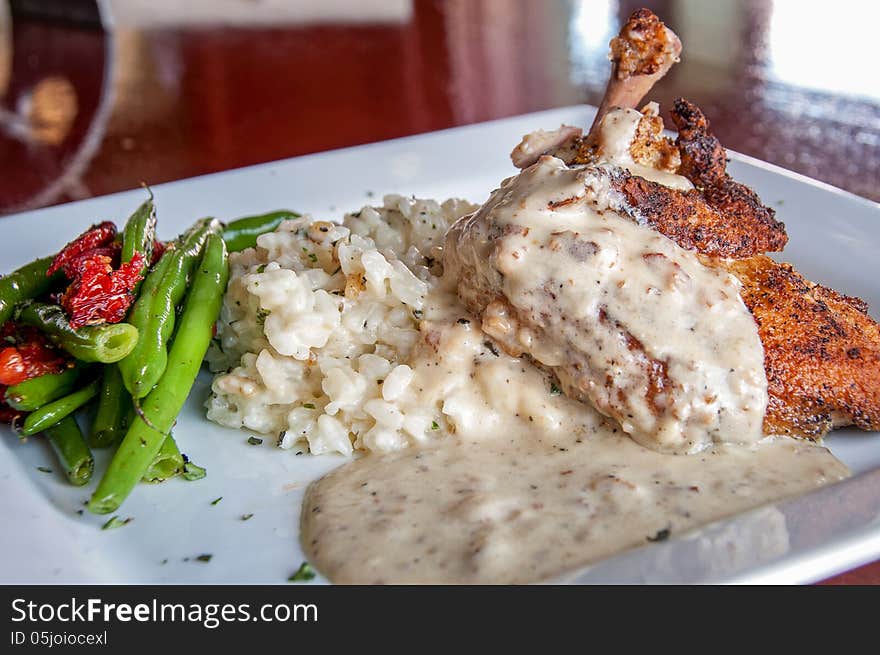 This is airline chicken...that has the bone cooked in with the chicken with a risotto and green beans. This is airline chicken...that has the bone cooked in with the chicken with a risotto and green beans.