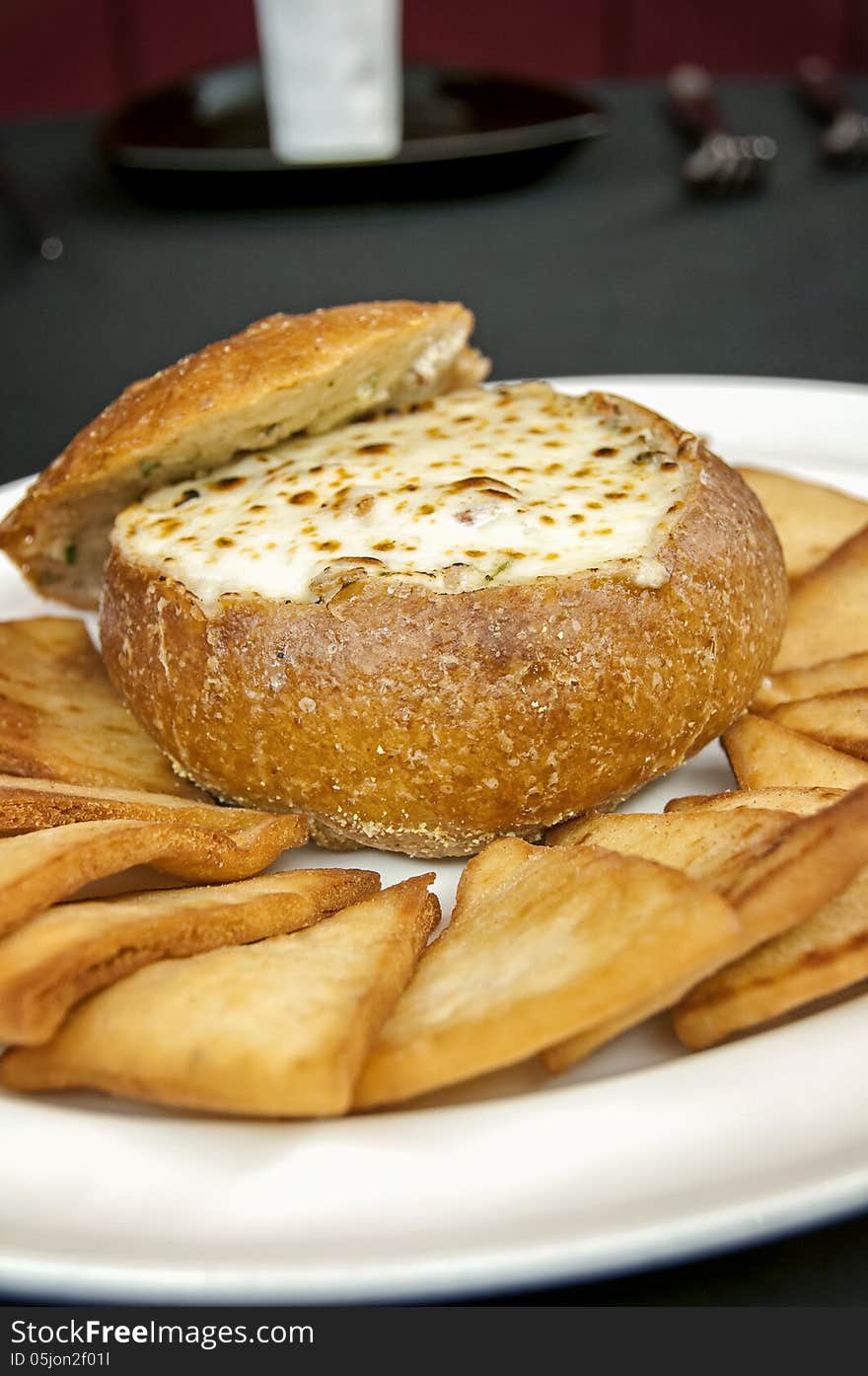 This is an artichoke cheese dip with a bread bowl with toast points. This is an appetizer at a high end restaurant