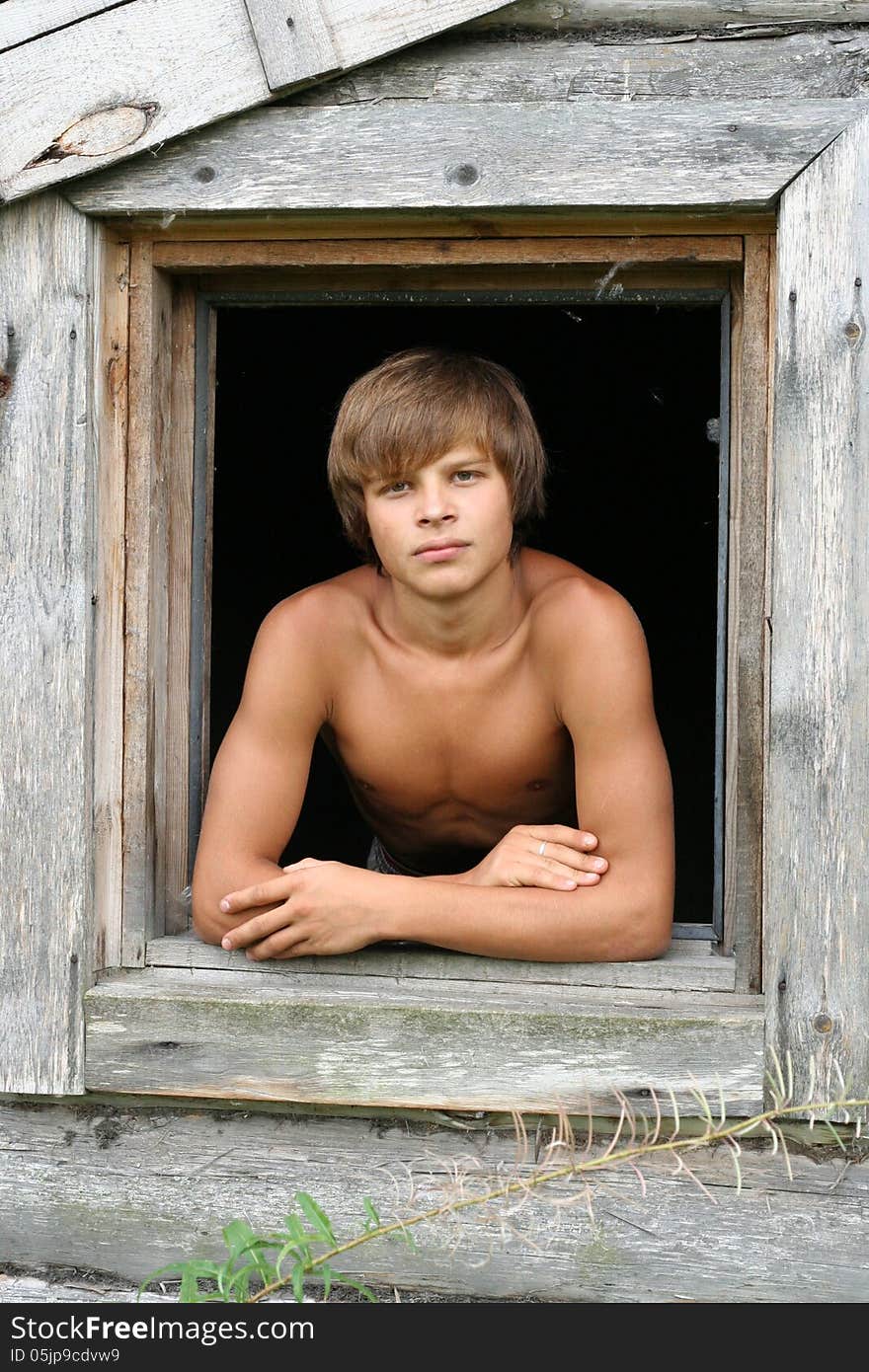 a young man in the window of the old house. a young man in the window of the old house