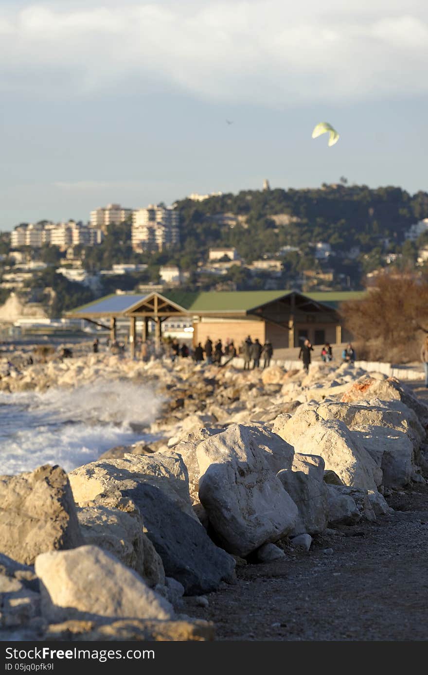 Beach along a rocky coastline. France, mediterranean coast. People having a walk on the beach. Beach along a rocky coastline. France, mediterranean coast. People having a walk on the beach.