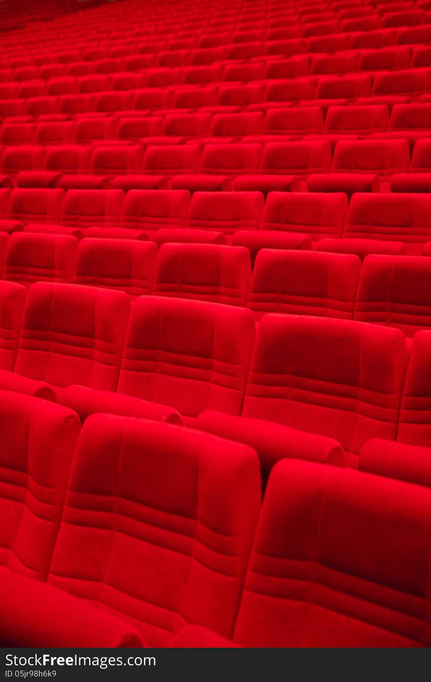 Rows of red arm-chairs in empty hall