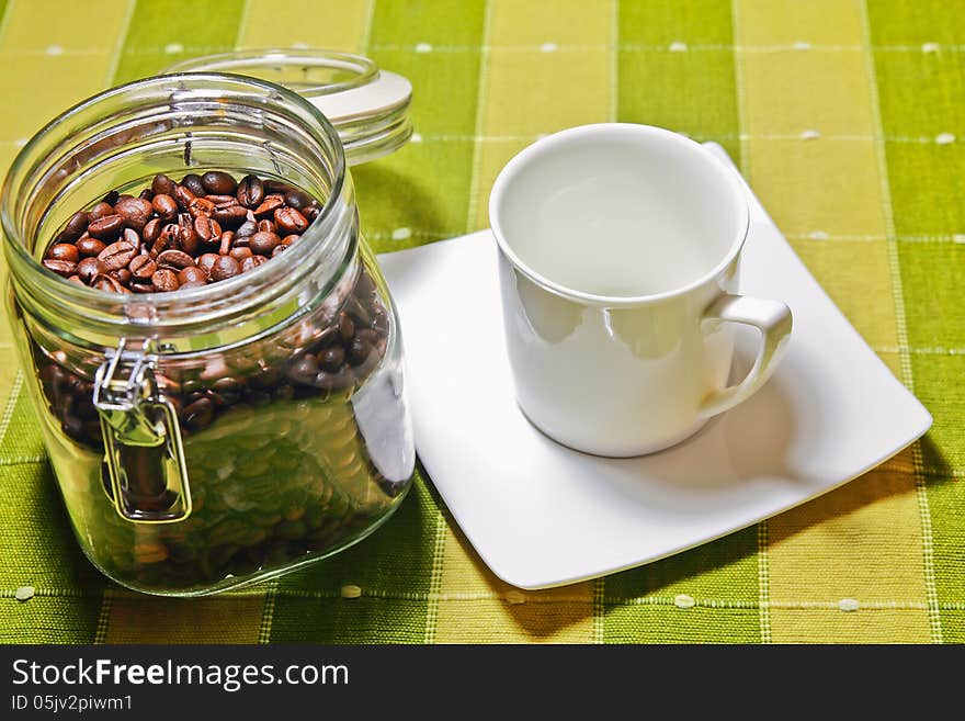 Coffee beans with white cup empty on the table