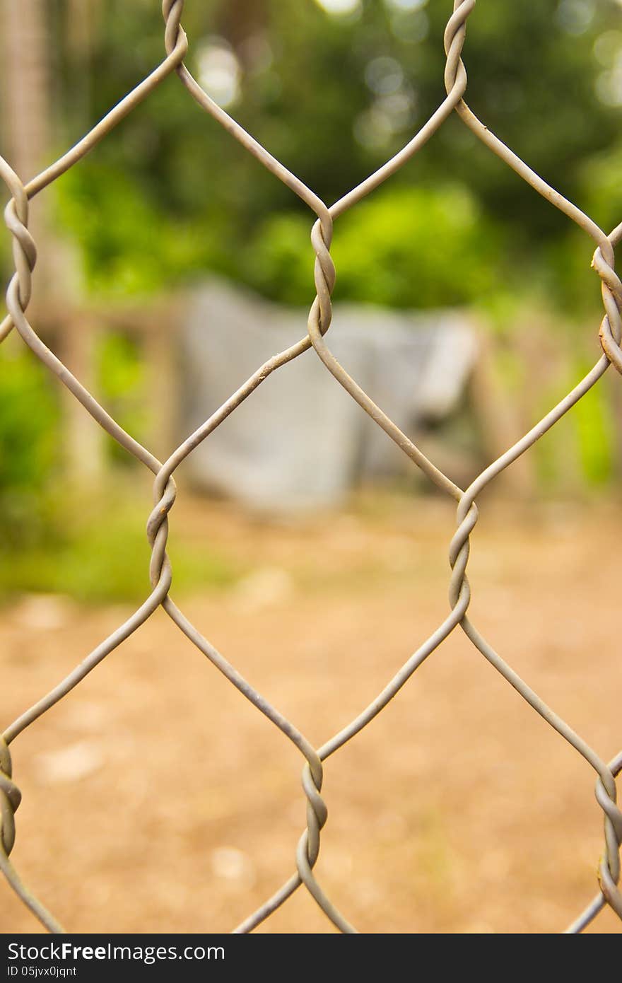 Metal mesh wire fence with blur garden background. Metal mesh wire fence with blur garden background