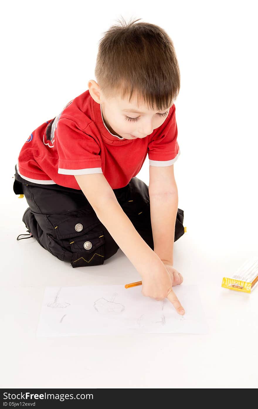 A little boy draws on the paper on white background