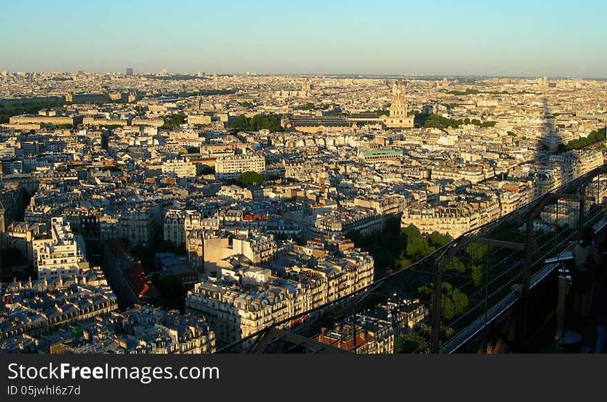 Sunset aerial view of Paris from the Eiffel tower with its shadow projecting over the city