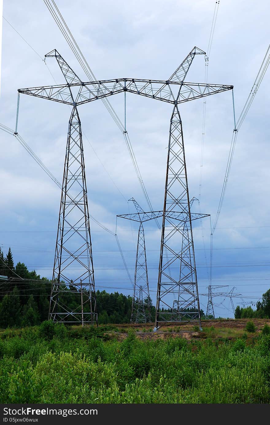 Electrical pylons against the cloudy sky background. Electrical pylons against the cloudy sky background