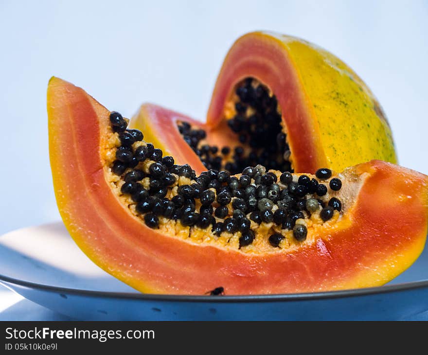 Pieces of papaya with orange flesh and black seeds.