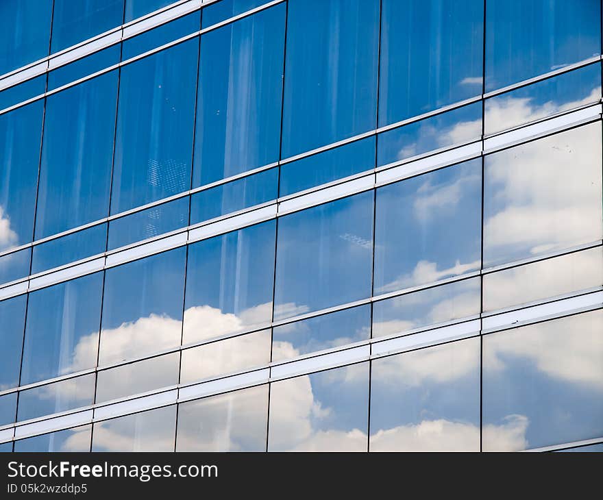 Clouds reflected in windows of modern office building